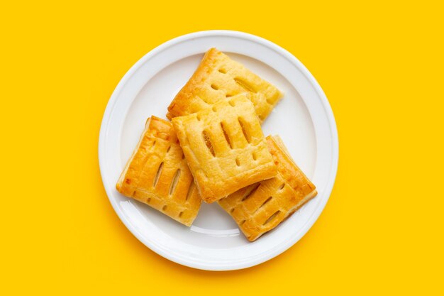 Pineapple pie in white plate on yellow background