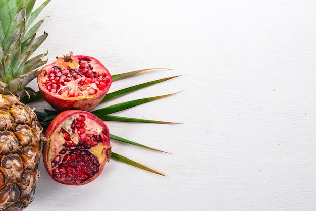 Pineapple and pomegranate Fresh fruits On a wooden background Top view Free space for text