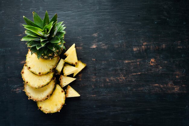 Pineapple. Sliced pineapple on a wooden background. Top view. Free copy space.