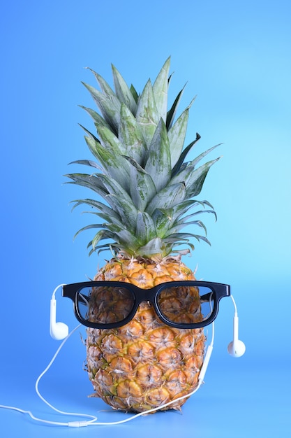 Pineapple in sunglasses and heardpods close-up