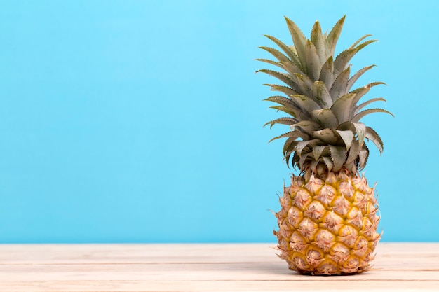 Pineapple on a table isolated on blue background