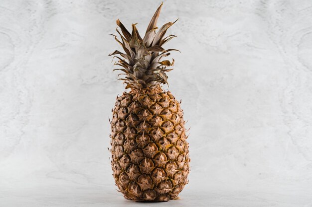 Pineapple tropical fruit on white stone table.