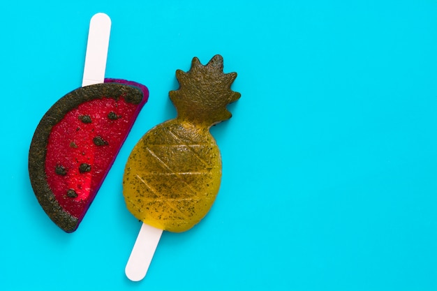 Pineapple and watermelon popsicles on blue