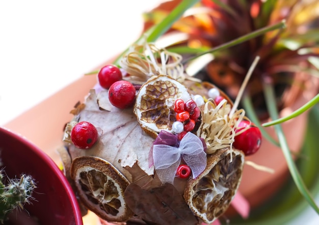 A pineapple with berries and leaves is decorated with a red flower