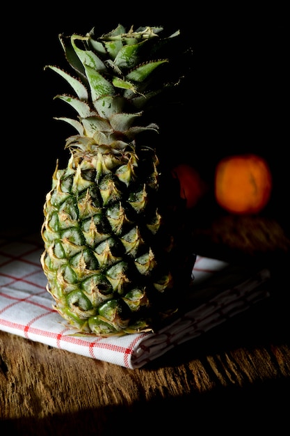 A pineapple with shadow on old chopping board in kitchen room at the morning 