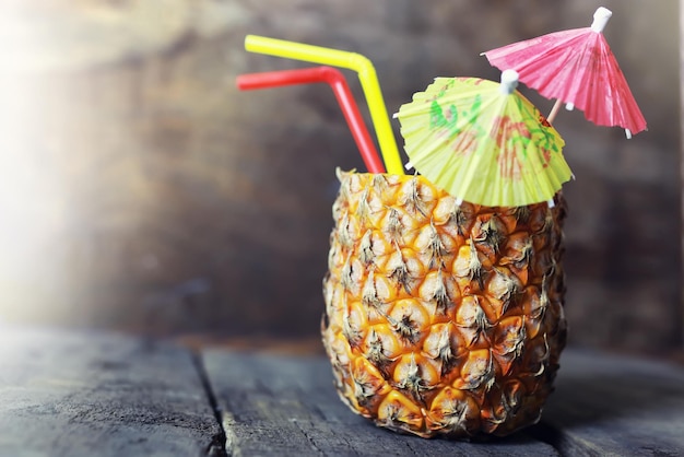 Pineapple with straw and cocktail umbrella