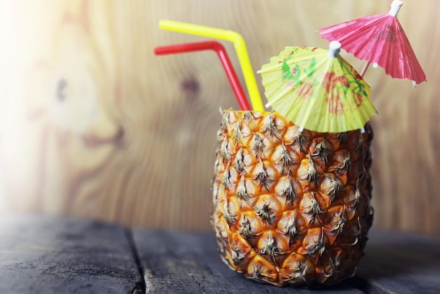 Pineapple with straw and cocktail umbrella