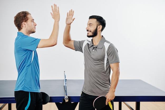 Ping pong players giving high five