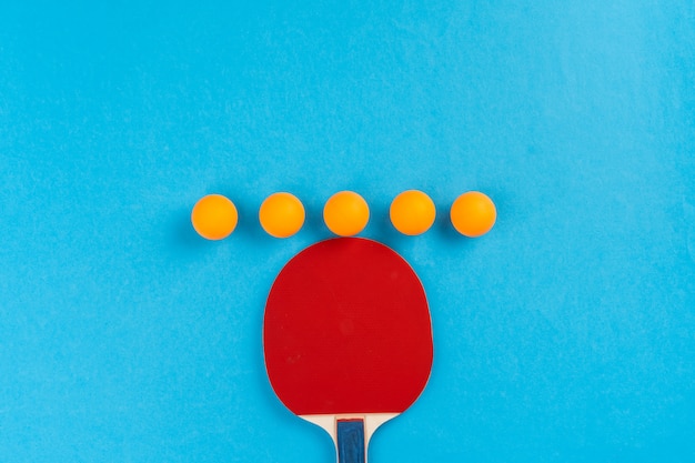 Foto racchetta e palla di ping-pong su fondo blu