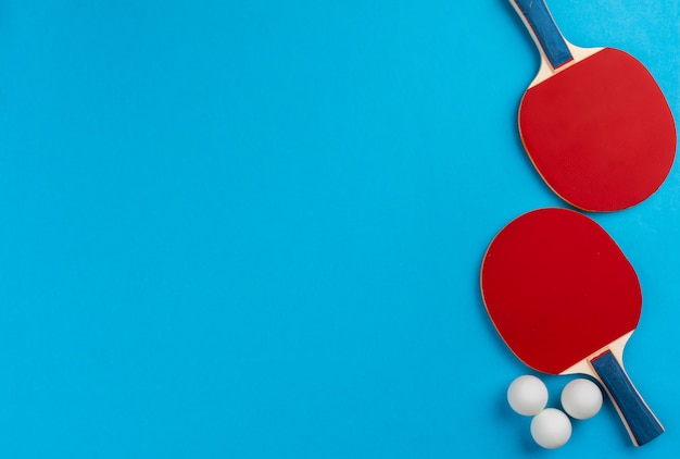 Ping pong racket and ball on blue background