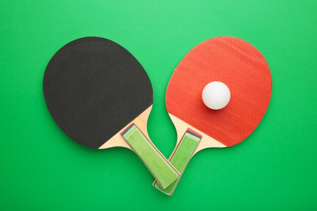 Ping pong rackets and balls on green surface