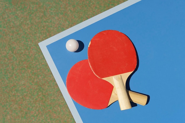 Sfondo di tavolo da ping pong tennis racchette da tennis e una palla su un tavolo sportivo blu