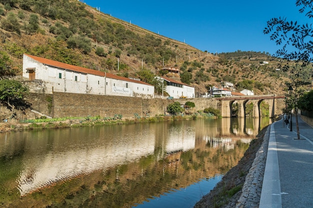 PINHAO DOURO REGION PORTUGAL OCTOBER 22 2017 View on Quinta do Sagrado and old stone bridge over Duoro river in Pinhao village Portugal