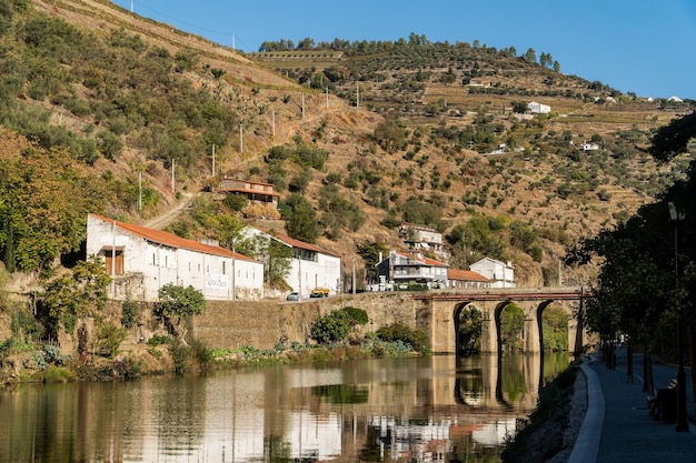 PINHAO DOURO REGION PORTUGAL OCTOBER 22 2017 View on Quinta do Sagrado and old stone bridge over Duoro river in Pinhao village Portugal