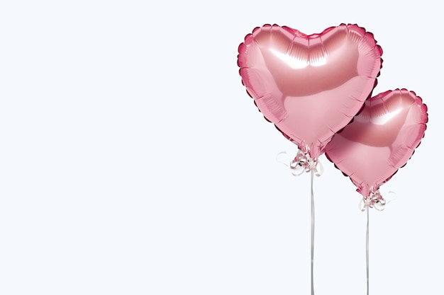 Pink air balloons heart shape on a white surface