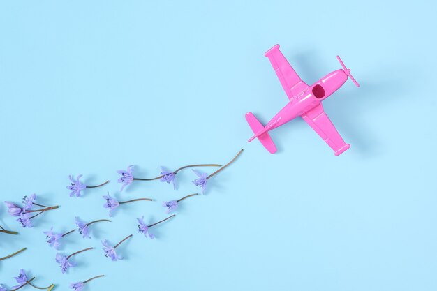 Pink airplane takes into a sharp turn on blue background