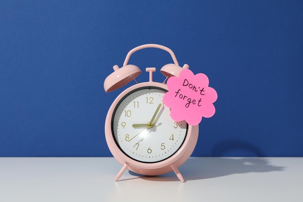 Photo pink alarm clock on a blue background