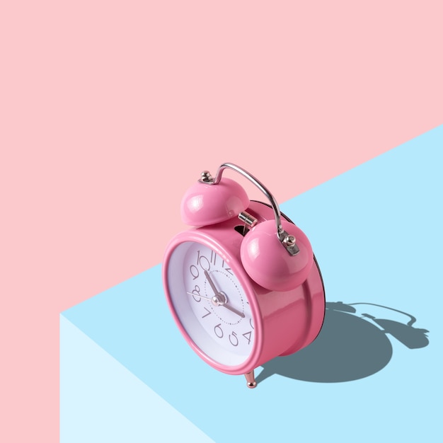 Photo pink alarm clock on bright background