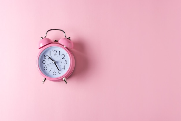 Pink alarm clock isolated on pastel pink