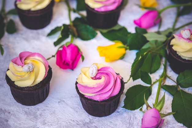 사진 자홍색과 노란 장미 꽃과 분홍색과 노란색 컵 케이크