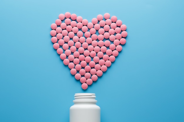 Photo pink b12 pills in the shape of a heart on a blue background