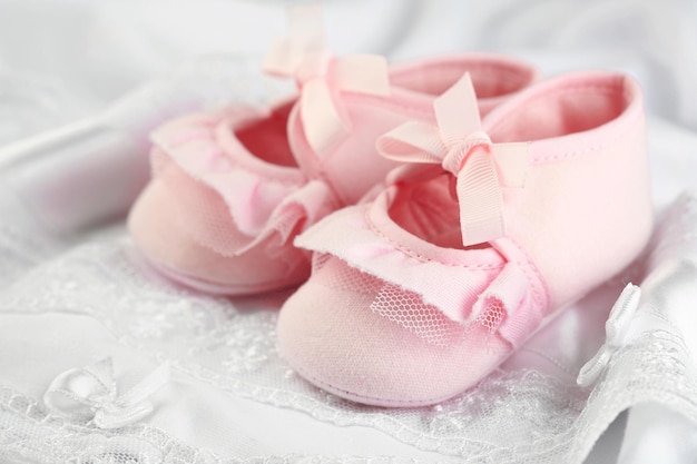 Photo pink baby boots on cloth closeup