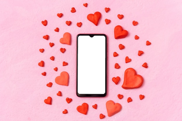On a pink background is a phone and a lot of different hearts.