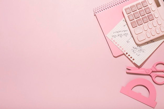 On a pink background pink school supplies a calculator cheat sheets