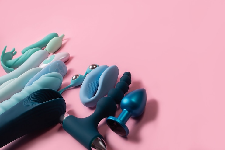 ピンクの背景のセックス製品で、大人のためのおもちゃ