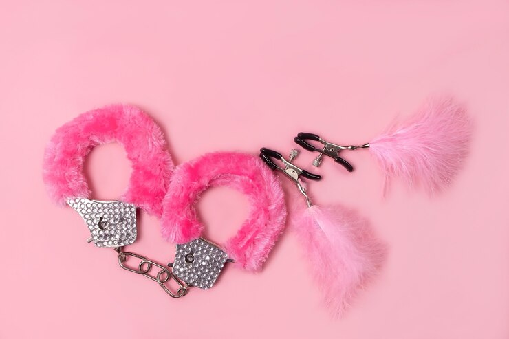 ピンクの背景のセックス製品で、大人のためのおもちゃ