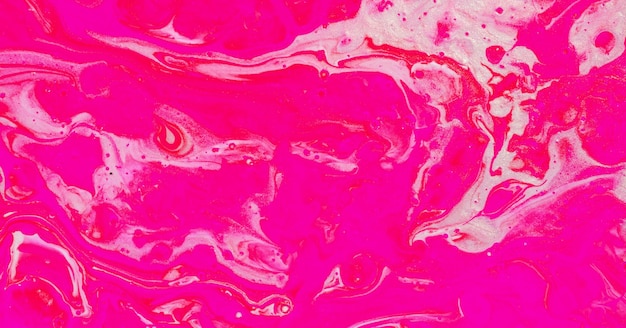 A pink background with a drop of paint in the middle