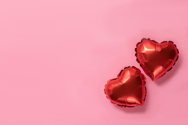 Pink background with red hearts balloons