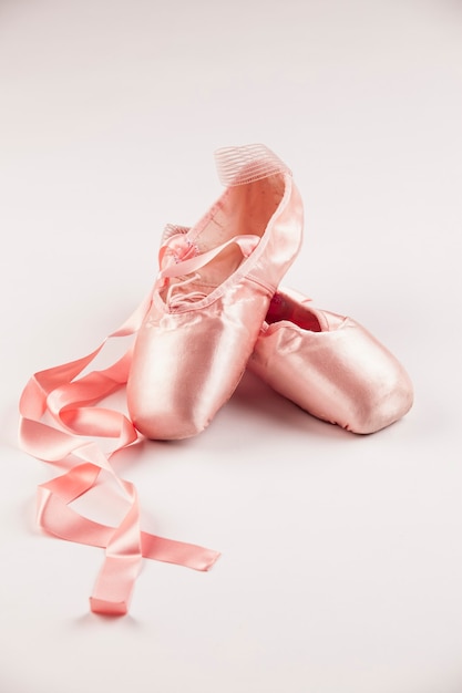 写真 白い床にピンクのバレエシューズ。