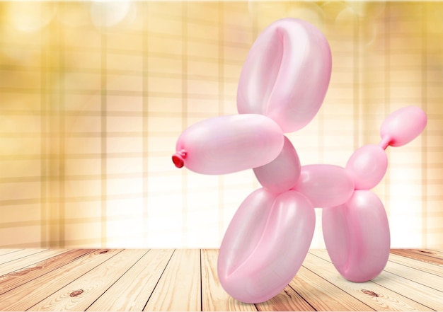 Pink balloon in form of dog on background