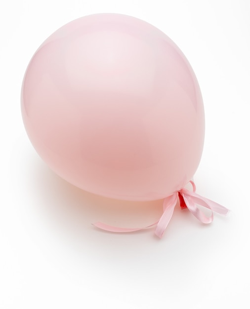 Foto palloncino rosa con delicati fiocchi bianchi. isolato su sfondo bianco.