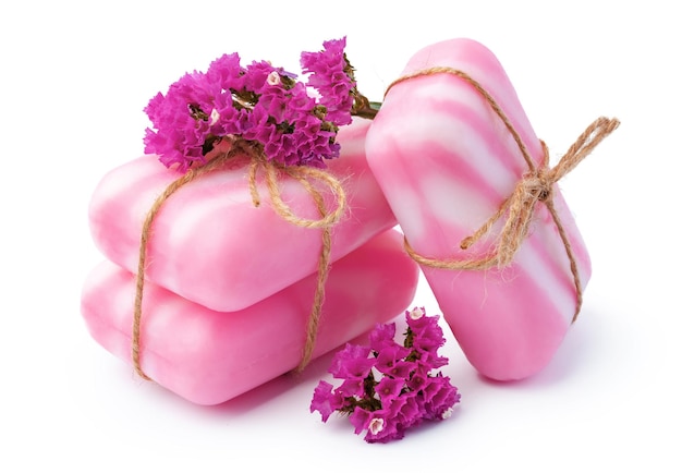 Pink bars of handmade natural soap and flowers isolated on white