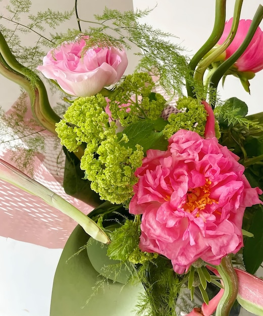 A pink basket with flowers and green leaves