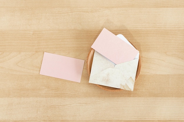 Pink blank paper card with rustic envelope recycled paper on wooden desk