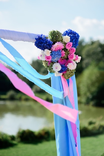 Foto fiori rosa e blu e ortensie decorano l'altare nuziale all'esterno