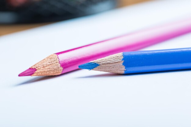 Pink and blue pencils with a white paper sheet