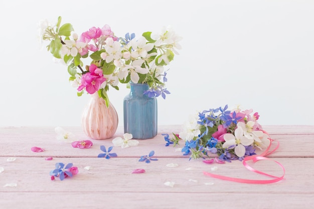 Pink and blue spring flowers on wooden table