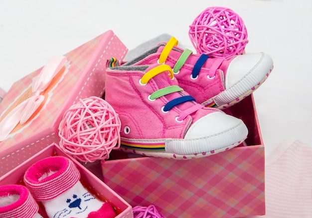 사진 흰색 격리된 배경에 분홍색 선물 상자에 있는 신생아를 위한 분홍색 옷과 양말