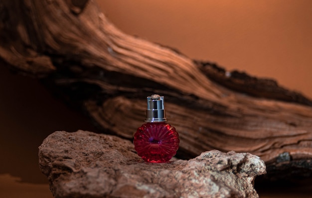 Photo pink bottle cosmetic glass bottle on beige background with wood and stone