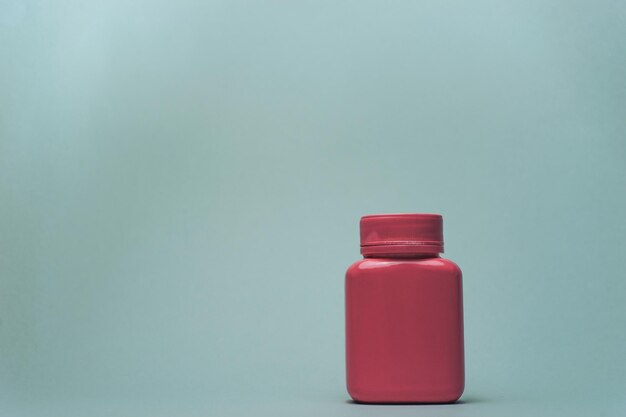 Pink bottle for pills on a gray background