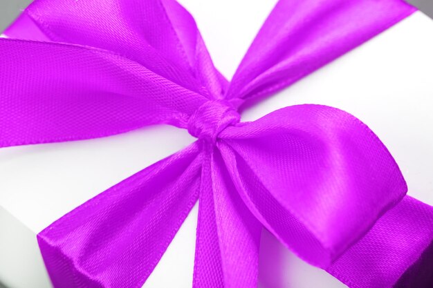 Pink bow on a gift made of fabric on a white background.
