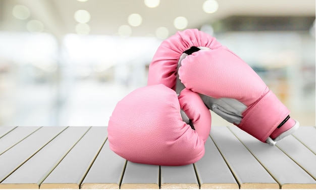 Photo pink boxing gloves on wooden background