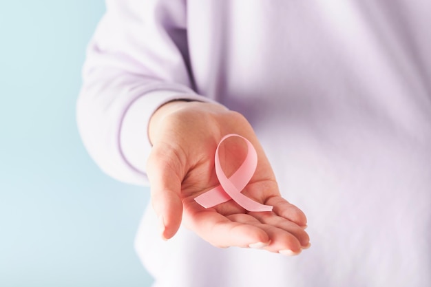 Pink Breast Cancer Awareness Ribbon Female hands holding pink ribbon on blue backgrounds Breast cancer awareness and October Pink day world cancer day Top view Mock up