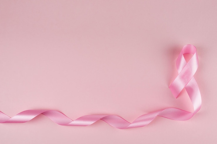 Pink breast cancer awareness ribbon with copy space pink backgrounnd