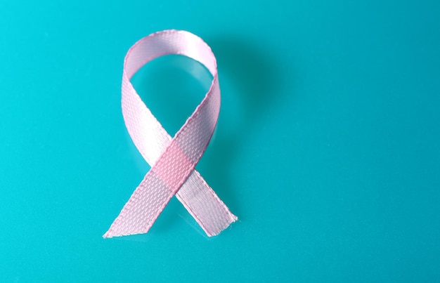 Pink breast cancer ribbon on blue background