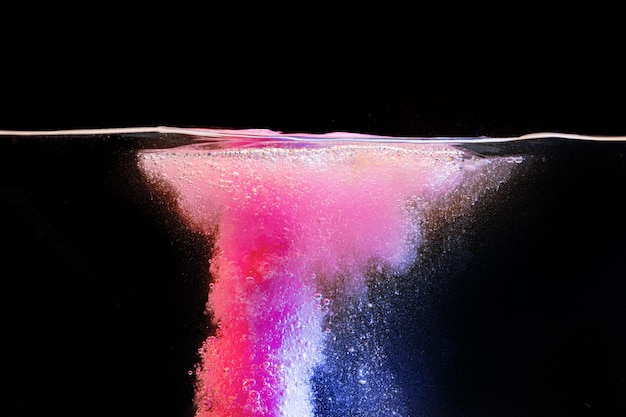 Pink bubbly boiling pool water against black background